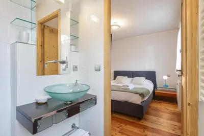 a bathroom with a sink and a bed in a room at Vallet - Spacieux Lumineux 100m2 Centre Vue Parking in Chamonix-Mont-Blanc
