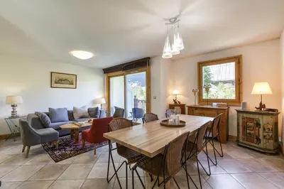a living room with a table and a couch at Vallet - Spacieux Lumineux 100m2 Centre Vue Parking in Chamonix-Mont-Blanc