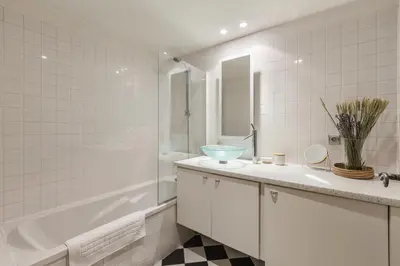 a white bathroom with a tub and a sink and a bath tubermott at Vallet - Spacieux Lumineux 100m2 Centre Vue Parking in Chamonix-Mont-Blanc