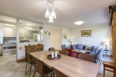 a living room with a table and a couch at Vallet - Spacieux Lumineux 100m2 Centre Vue Parking in Chamonix-Mont-Blanc