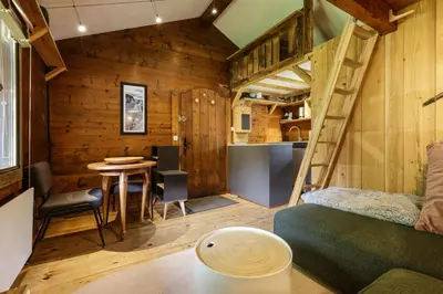 a living room with a bunk bed and a table at Baribal - Charmant Mazot Terrasse Nature Vue Parking in Chamonix-Mont-Blanc