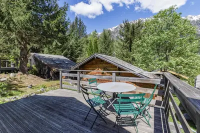 a table and chairs on the deck of a cabin at Baribal - Charmant Mazot Terrasse Nature Vue Parking in Chamonix-Mont-Blanc