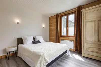 a bedroom with a white bed and a window at Epicea - Cosy 1CH 35m2 Centre Parking Calme WIFI in Chamonix-Mont-Blanc