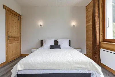 a bedroom with a large bed with white sheets at Epicea - Cosy 1CH 35m2 Centre Parking Calme WIFI in Chamonix-Mont-Blanc
