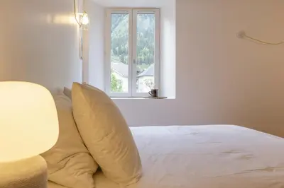 a bed with two pillows on it with a window at Cinema - Lumineux Moderne 2CH 100m2 Hypercentre Vues in Chamonix-Mont-Blanc