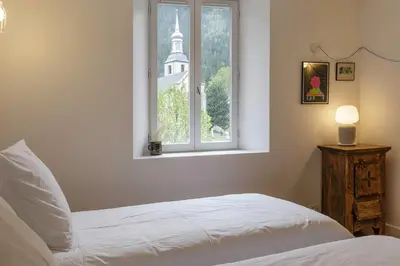 a bedroom with a white bed and a window at Cinema - Lumineux Moderne 2CH 100m2 Hypercentre Vues in Chamonix-Mont-Blanc