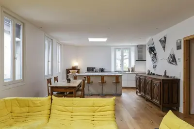 a living room with a yellow couch and a kitchen at Cinema - Lumineux Moderne 2CH 100m2 Hypercentre Vues in Chamonix-Mont-Blanc