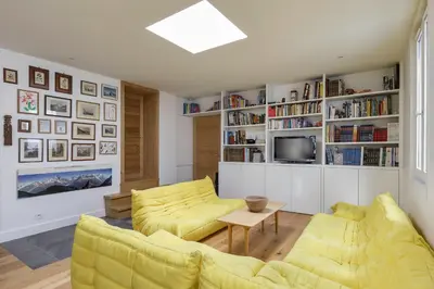 a living room with two yellow chairs and a television at Cinema - Lumineux Moderne 2CH 100m2 Hypercentre Vues in Chamonix-Mont-Blanc