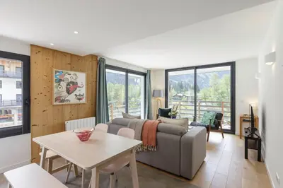 a living room with a couch and a table at Cordee - Appart 2CH Balcon SUD Vues Residence Premium in Chamonix-Mont-Blanc
