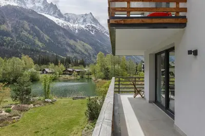 a house with a view of a lake and mountains at Cordee - Appart 2CH Balcon SUD Vues Residence Premium in Chamonix-Mont-Blanc