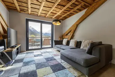 a living room with a couch and a television at Flocon - Loft Moderne 8pax Sauna Poele Vues Garage in Chamonix-Mont-Blanc
