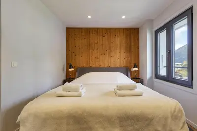 a bedroom with a large bed with two towels on it at Flocon - Loft Moderne 8pax Sauna Poele Vues Garage in Chamonix-Mont-Blanc