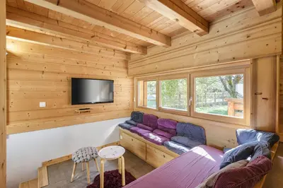a log cabin living room with a couch and a tv at Gaillands Mazot Lumineux 55m2 Vues Confort in Chamonix-Mont-Blanc