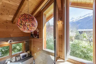 a room with a large window and a chandelier at Gaillands Mazot Lumineux 55m2 Vues Confort in Chamonix-Mont-Blanc