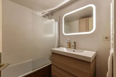a bathroom with a sink and a mirror and a tub at Refuge Scandinave - Duplex 80m2 Vue Garage Calme 200m TrainBus in Chamonix-Mont-Blanc