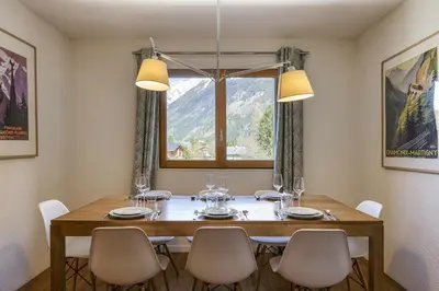 a dining room with a table and chairs and a window at Refuge Scandinave - Duplex 80m2 Vue Garage Calme 200m TrainBus in Chamonix-Mont-Blanc