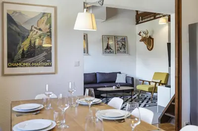 a dining room with a table with wine glasses on it at Refuge Scandinave - Duplex 80m2 Vue Garage Calme 200m TrainBus in Chamonix-Mont-Blanc
