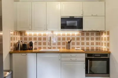 a kitchen with white cabinets and a counter top at Refuge Scandinave - Duplex 80m2 Vue Garage Calme 200m TrainBus in Chamonix-Mont-Blanc