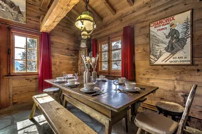 a dining room with a wooden table and chairs at Frasserands - Chalet 155m2 Vue 360 Calme Bus Train 150m in Chamonix-Mont-Blanc