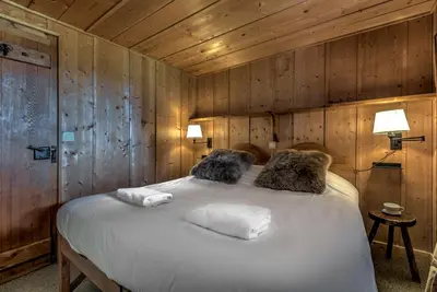 a bedroom with a large bed with wooden walls at Frasserands - Chalet 155m2 Vue 360 Calme Bus Train 150m in Chamonix-Mont-Blanc