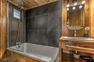a bathroom with a bath tub and a sink at Frasserands - Chalet 155m2 Vue 360 Calme Bus Train 150m in Chamonix-Mont-Blanc