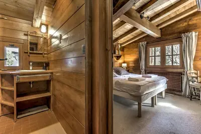 a bedroom with a bed in a room with wooden walls at Frasserands - Chalet 155m2 Vue 360 Calme Bus Train 150m in Chamonix-Mont-Blanc