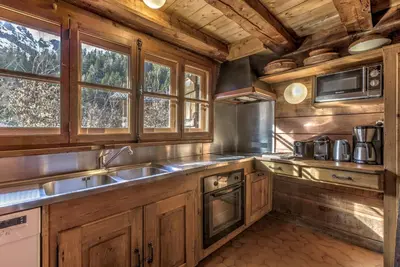a kitchen with wooden cabinets and a sink at Frasserands - Chalet 155m2 Vue 360 Calme Bus Train 150m in Chamonix-Mont-Blanc