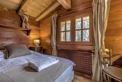 a bedroom with a bed in a wooden cabin at Frasserands - Chalet 155m2 Vue 360 Calme Bus Train 150m in Chamonix-Mont-Blanc