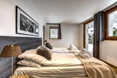 a bedroom with a large bed with pillows on it at Chosalets - Chalet 200m2 Cheminee Jacuzzi Sauna Vues in Chamonix-Mont-Blanc