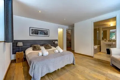 a bedroom with a bed and a living room at Chosalets - Chalet 200m2 Cheminee Jacuzzi Sauna Vues in Chamonix-Mont-Blanc