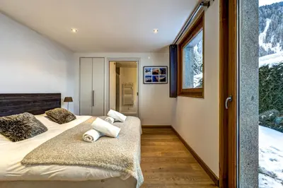 a bedroom with two beds and a window at Chosalets - Chalet 200m2 Cheminee Jacuzzi Sauna Vues in Chamonix-Mont-Blanc