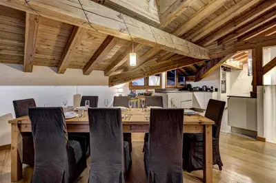a dining room with a wooden table and chairs at Chosalets - Chalet 200m2 Cheminee Jacuzzi Sauna Vues in Chamonix-Mont-Blanc