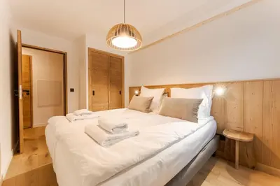 a bedroom with a large bed with white sheets at Chatelet Appart 3CH Proche remontees Centrale Vues in Saint-Gervais-les-Bains