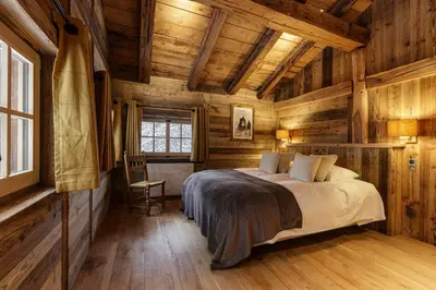 a bedroom with a bed in a wooden cabin at Lavancher - Chalet 400m2 Ferme 1803 renovee Sauna Billard in Chamonix-Mont-Blanc