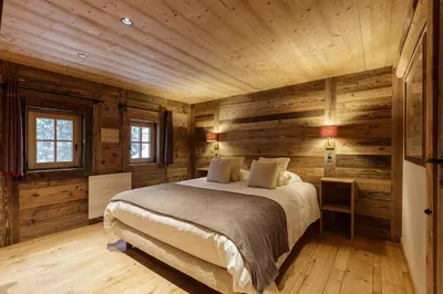 a bedroom with a bed in a wooden cabin at Lavancher - Chalet 400m2 Ferme 1803 renovee Sauna Billard in Chamonix-Mont-Blanc