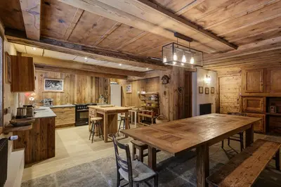 a kitchen and dining room with a wooden table at Lavancher - Chalet 400m2 Ferme 1803 renovee Sauna Billard in Chamonix-Mont-Blanc