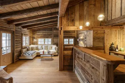 a living room with a couch and wooden walls at Lavancher - Chalet 400m2 Ferme 1803 renovee Sauna Billard in Chamonix-Mont-Blanc