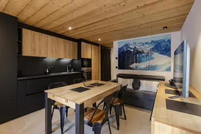 a kitchen and dining room with a table and a couch at Vouvy - Moderne 4pax Remontee Flegere 5min Praz Arve in Chamonix-Mont-Blanc