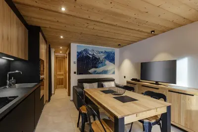 a kitchen and dining room with a wooden table at Vouvy - Moderne 4pax Remontee Flegere 5min Praz Arve in Chamonix-Mont-Blanc