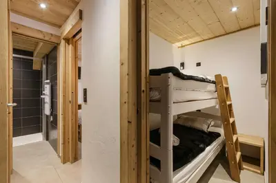 a room with two bunk beds and a bathroom at Vouvy - Moderne 4pax Remontee Flegere 5min Praz Arve in Chamonix-Mont-Blanc