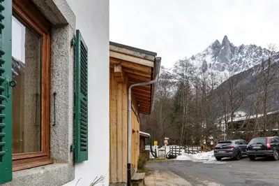 a building with a window with a view of a mountain at Vouvy - Moderne 4pax Remontee Flegere 5min Praz Arve in Chamonix-Mont-Blanc