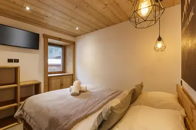 a bedroom with a bed with a tv on the wall at Vouvy - Moderne 4pax Remontee Flegere 5min Praz Arve in Chamonix-Mont-Blanc