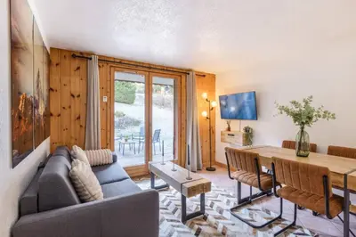 a living room with a couch and a table at Griaz - Cocon 1CH Terrasse Confort Bureau Parking in Les Houches