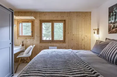 a bedroom with a bed and a desk and two windows at Griaz - Cocon 1CH Terrasse Confort Bureau Parking in Les Houches
