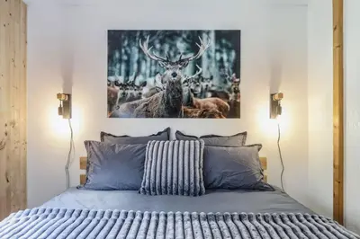 a bedroom with a bed with a picture of a deer at Griaz - Cocon 1CH Terrasse Confort Bureau Parking in Les Houches