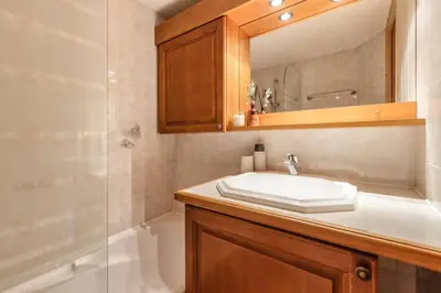 a bathroom with a sink and a mirror and a shower at Griaz - Cocon 1CH Terrasse Confort Bureau Parking in Les Houches