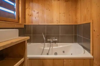 a bath tub in a bathroom with wooden cabinets at Ibex - Chalet 170m2 Cheminee Vue Confort Calme in Les Houches