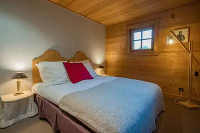 a bedroom with a large bed with a red pillow at Ibex - Chalet 170m2 Cheminee Vue Confort Calme in Les Houches