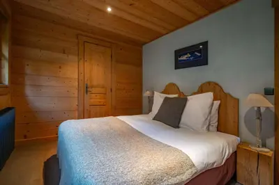 a bedroom with a bed in a room with wooden walls at Ibex - Chalet 170m2 Cheminee Vue Confort Calme in Les Houches
