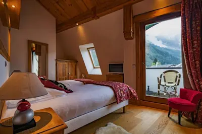 a bedroom with a bed and a large window at Astoria - UltraCentral 140m2 Balcons Vues Balneo Sauna in Chamonix-Mont-Blanc